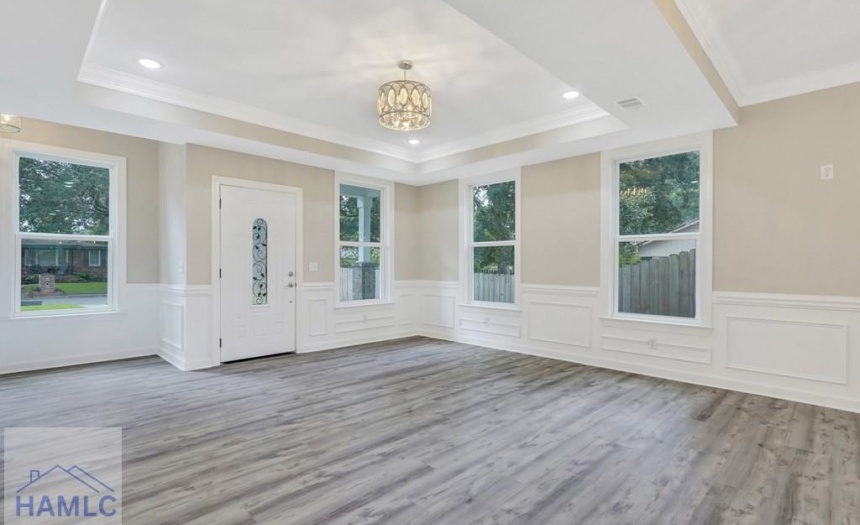 Open concept living/dining room area with crown mo