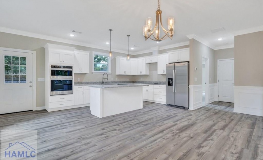 Open concept living/dining room area with crown mo