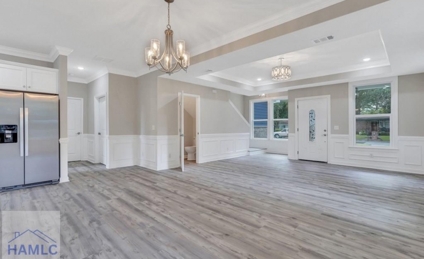 Open concept living/dining room area with crown mo