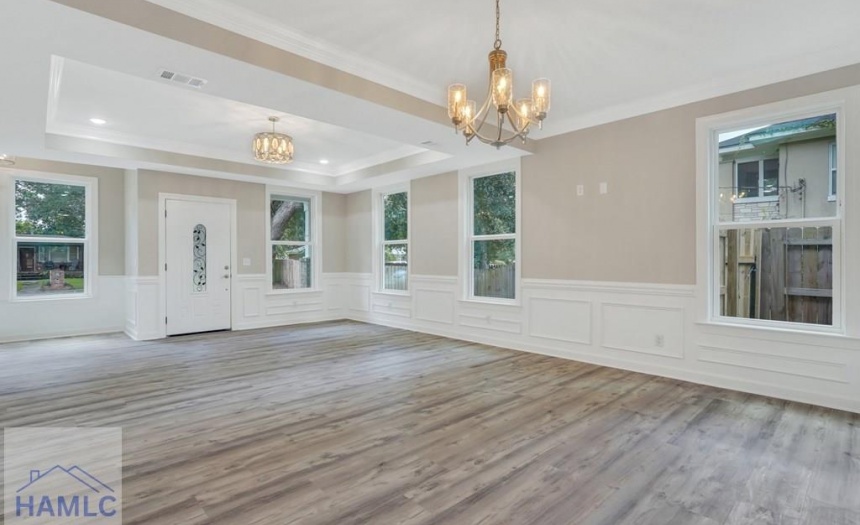 Open concept living/dining room area with crown mo