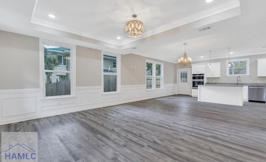 Open concept living/dining room area with crown mo